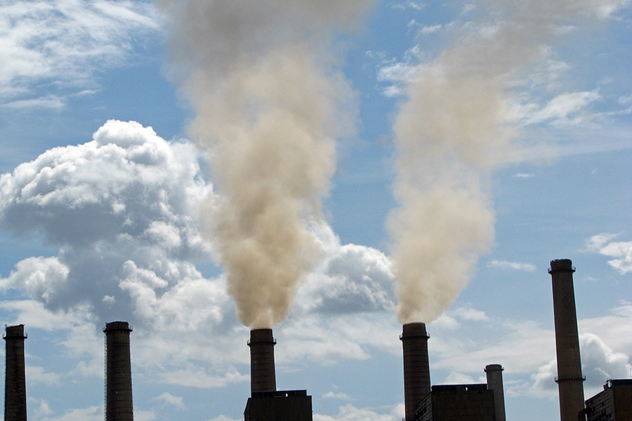 smokestacks with smoke rising in a blue sky